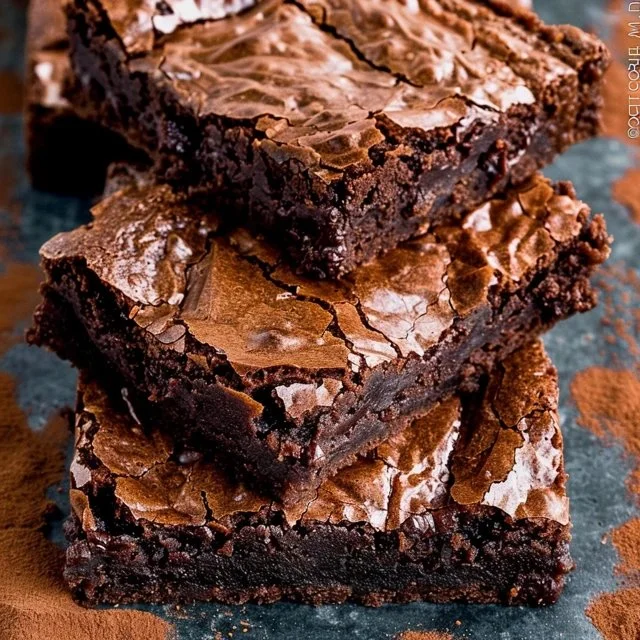 best-brownies-ever-2026-04-09-195127 Rich and fudgy brownies on a plate with chocolate drizzle and nuts