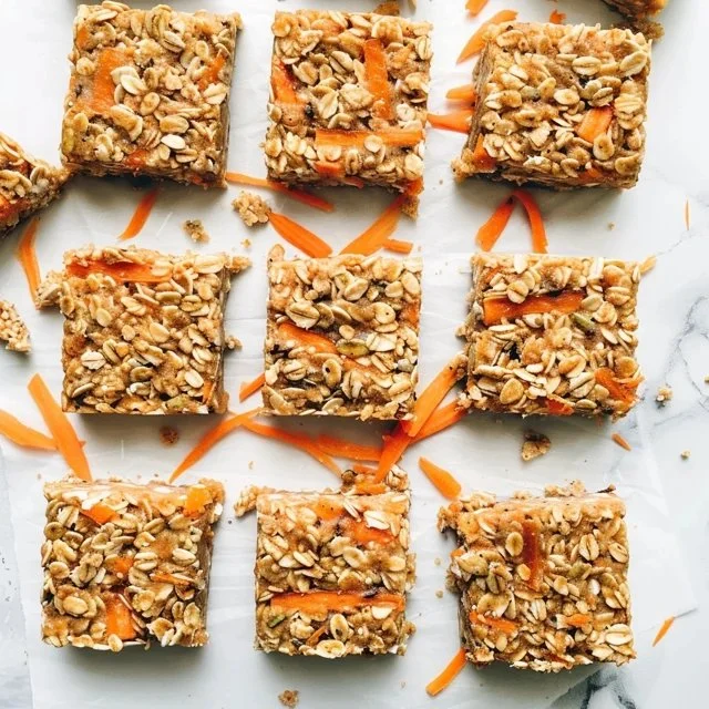 Delicious carrot cake granola bars with nuts and spices on a wooden table