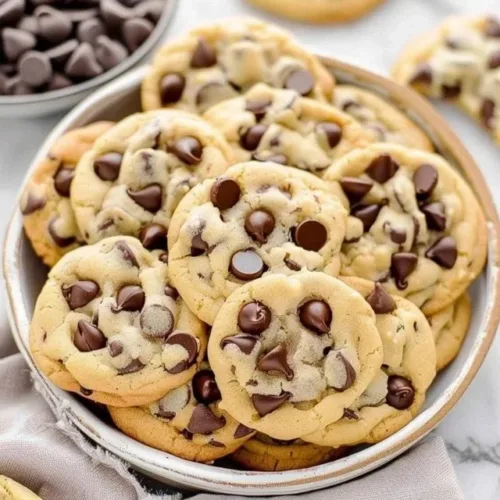 Freshly baked chocolate chip cookies on a cooling rack.