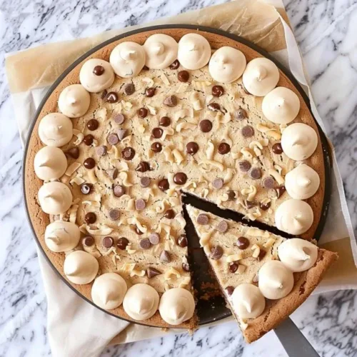 Delicious homemade cookie cake topped with chocolate chips and frosting