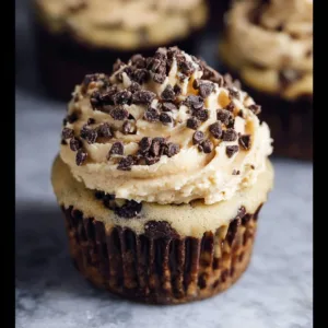 Decadent cookie dough cupcakes topped with chocolate frosting and cookie pieces