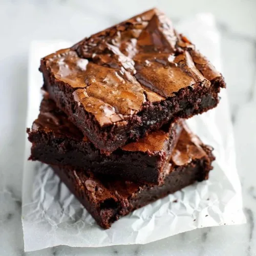 Delicious fudgy brownies on a plate, showcasing the perfect chocolatey texture.