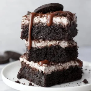Delicious Oreo Brownies topped with Oreo cookie pieces and chocolate drizzle