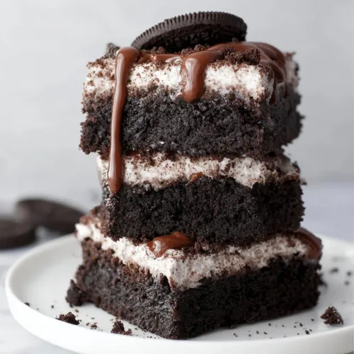 Delicious Oreo Brownies topped with Oreo cookie pieces and chocolate drizzle
